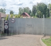 За газоном и деревьями, ухаживает садовник.