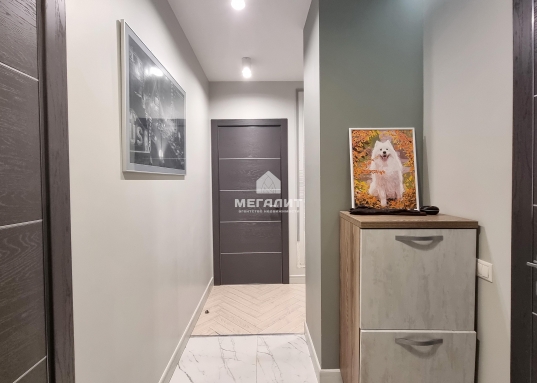 Уютная спальная комната выполнена в спокойных тонах, что создает атмосферу отдыха и комфорта.